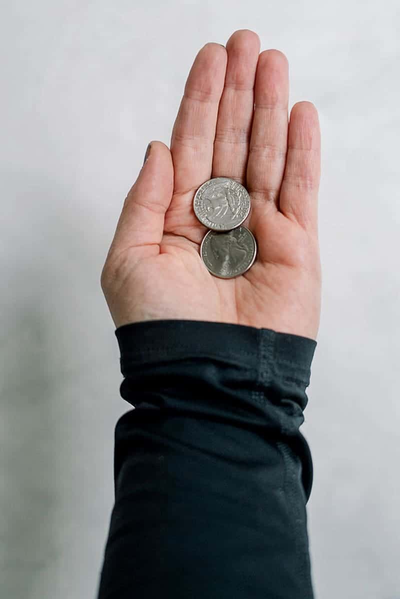 person holding two coins